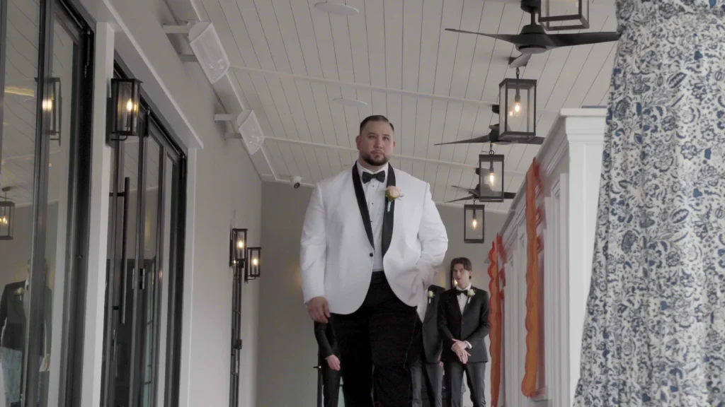 Groom in a white dinner jacket walking to the ceremony at the Sokol wedding in Charleston, SC