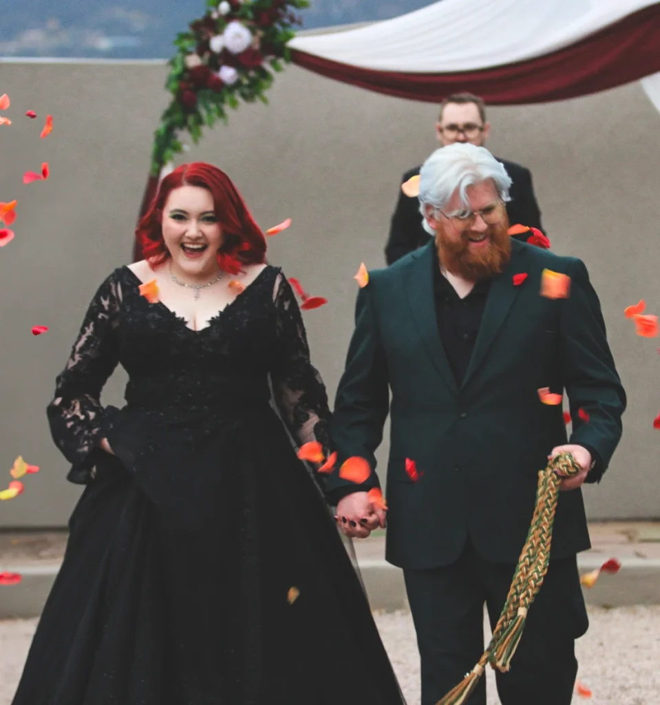 Matt and Caisy Barnes celebrating as they walk back down the aisle in Colorado Springs, CO